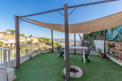 a canopy on a balcony with a table and chairs at Vila Viva Mundo in San Cipriano de Vallalta
