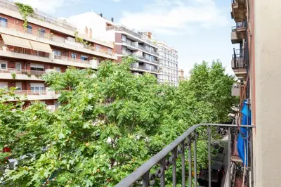 a balcony with trees in front of a building at Urgell in Barcelona