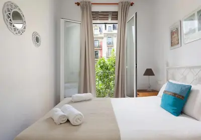 a bedroom with a large bed with towels on it at Urgell in Barcelona