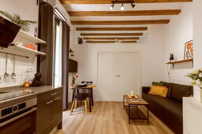 a kitchen and living room with a couch and a table at Lodging Apartments Almirall Beach 12 in Barcelona