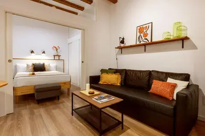 a living room with a couch and a bed at Lodging Apartments Almirall Beach 12 in Barcelona