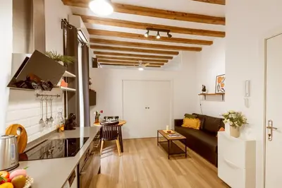 a kitchen and living room with a couch and a table at Lodging Apartments Almirall Beach 12 in Barcelona