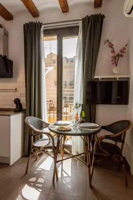 a dining room with a table and chairs and a window at Lodging Apartments Almirall Beach 42 in Barcelona