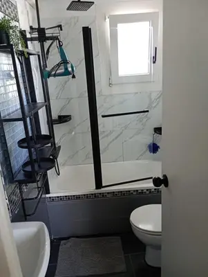 a bathroom with a shower and a toilet and a sink at Frente al mar con Terraza - Sitges in Sitges