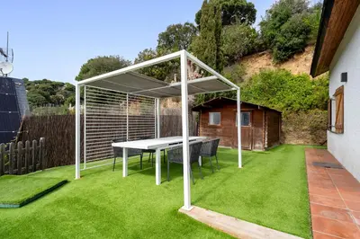 a living room with a wooden table and chairs at Hauzify I Casa Montjuïc in Sant Cebrià de Vallalta