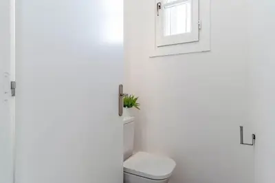 a white bathroom with a toilet and a window at 4182 - AB Poble Sec - Plaza España X in Barcelona