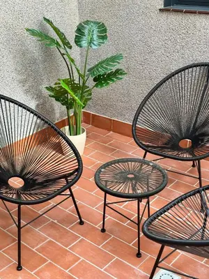 three chairs and a table and a potted plant at Stay U-nique Apartments at Albigesos in Barcelona