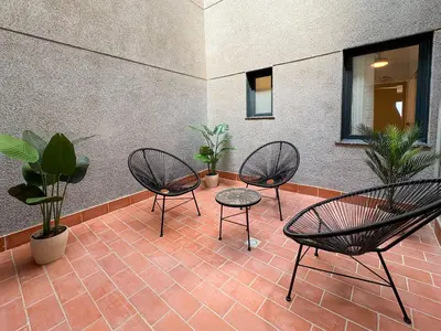 three chairs and a table on a patio with plants at Stay U-nique Apartments at Albigesos in Barcelona
