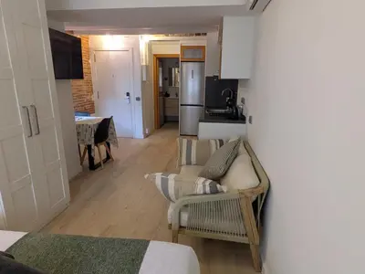 a living room with a couch and a kitchen at Barcelona Touch Apartments - Font Honrada in Barcelona