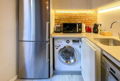 a kitchen with a stainless steel refrigerator and a washing machine at Barcelona Touch Apartments - Fontrodona in Barcelona