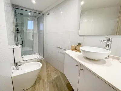 a white bathroom with a sink and a toilet at Barcelona Touch Apartments - Creu dels Molers in Barcelona