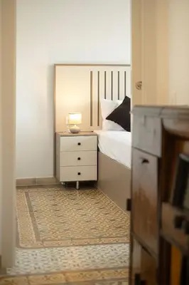 a bedroom with a bed and a dresser with a lamp on it at Catalan Charm 3BR w 15 Baths in Barcelona