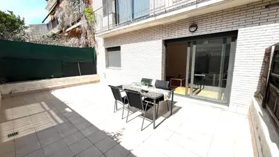 a patio with a table and chairs next to a building at Apartamento independiente con jardín in Terrassa