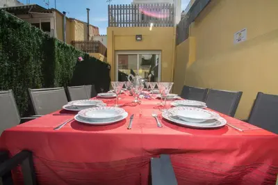 a table with a red table cloth and plates and glasses at Casa con piscina en el centro de Calella, Aire in Calella