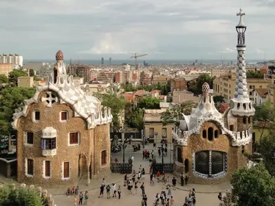 a group of people walking in front of a building at Park Guell in Barcelona
