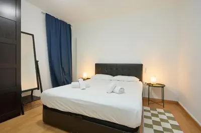 a bedroom with a large bed with white sheets and pillows at Park Guell in Barcelona