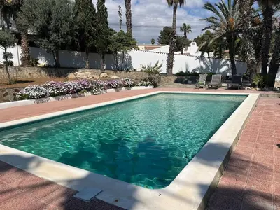 a swimming pool with blue water in a yard at Ibiza style villa with swimming pool near Sitges in Cunit