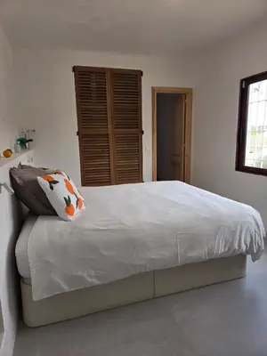 a bedroom with a large white bed with pillows at Ibiza style villa with swimming pool near Sitges in Cunit