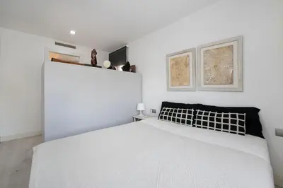 a white bedroom with a large bed in it at Namasté by Seaside Homes in Castelldefels