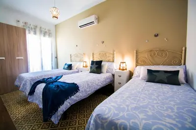 a bedroom with two beds with blue and white sheets at Casa grande con piscina en el centro de Calella, Tramuntana in Calella