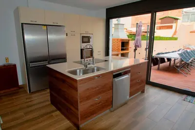 a kitchen with a stainless steel refrigerator and a sink at Casa grande con piscina en el centro de Calella, Tramuntana in Calella
