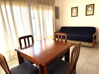 a room with a table and chairs and a bed at Apartamento Pineda de Mar en Primera Línea in Pineda de Mar