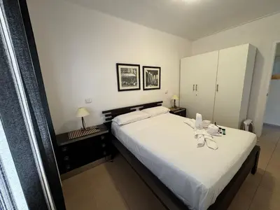 a bedroom with a large white bed and a cabinet at Apartamento Pineda de Mar con Vistas al Mar in Pineda de Mar