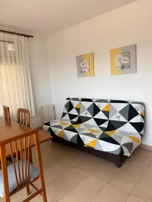a bedroom with a bed and a dining room table at Apartamento Pineda de Mar con Vistas al Mar in Pineda de Mar