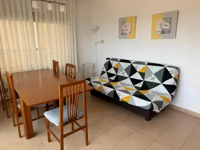 a dining room with a table and a couch at Apartamento Pineda de Mar con Vistas al Mar in Pineda de Mar