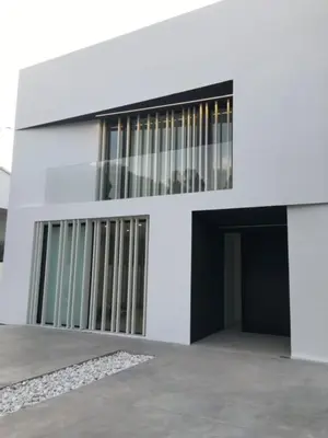 a white building with a black door and a doorway at Casa de lujo en Gavá mar in Gavà