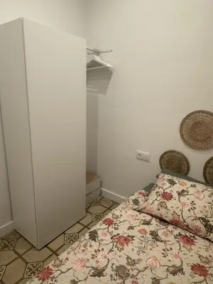 a small bedroom with a bed and a cabinet at The Perfect Nomad's Home - Barcelona in Barcelona