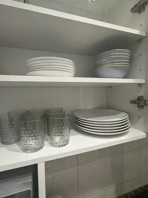 a kitchen shelf with plates and bowls on it at The Perfect Nomad's Home - Barcelona in Barcelona