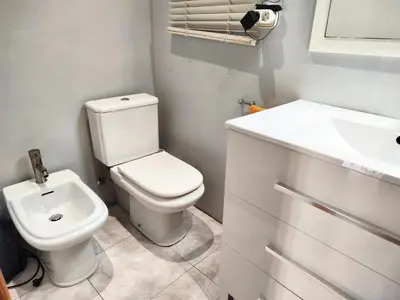 a bathroom with a white toilet and a sink at La habitación de Santa Eulalia in Hospitalet de Llobregat