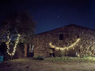 a barn with christmas lights on it at night at La Coma in gualba de Dalt