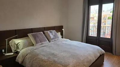 a bedroom with a large bed with a large window at Opening Doors Summer Chic in Barcelona