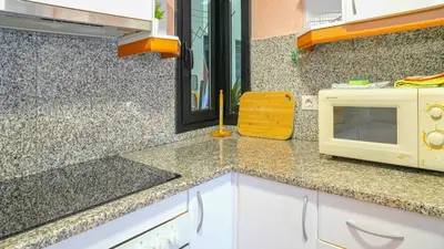 a kitchen with a counter top with a microwave at Vivalidays Margarita - Pineda de Mar in Pineda de Mar