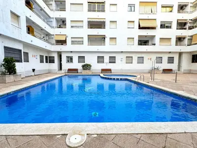 a large swimming pool in front of a building at Apartamento con Terraza,Piscina,Playa y Aire acondicionado in Pineda de Mar