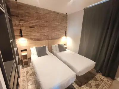 two beds in a room with a brick wall at Two bedrooms bright apartment center Barcelona in Barcelona