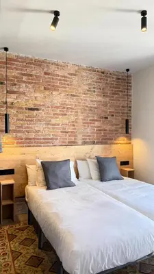 a large bed in a room with a brick wall at Two bedrooms bright apartment center Barcelona in Barcelona