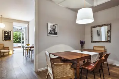 a dining room with a table and chairs and a mirror at The Conica Deluxe Bed&Breakfast in Barcelona