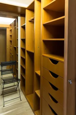a walk in closet with wooden shelves and a chair at Stunning sea views over marina with swimming pool in Sitges