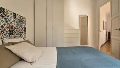 a bedroom with a white bed with a blue blanket at Opening Doors Sant Pau II Centric AACC in Barcelona
