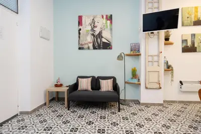 a living room with a couch and a tv on a wall at EXT Studio todo equipado, 15' de BCN centro 8' playa in Sant Adria de Besos