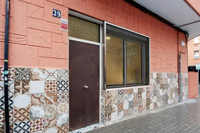 a door on the side of a red building at EXT Studio todo equipado, 15' de BCN centro 8' playa in Sant Adria de Besos