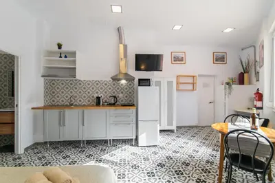 a kitchen with white appliances and a table and chairs at INT Studio totalmente equipado, 15' de BCN centro 8' playa in Sant Adria de Besos