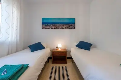 two twin beds in a room with a table at 2º Apartamento 3 hab 15' Barcelona centro y 8' Playa caminando in Sant Adria de Besos