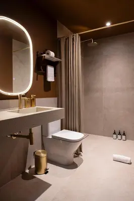 a bedroom with a bed and a table and a mirror at Hotel Vella Nit in Canet de Mar