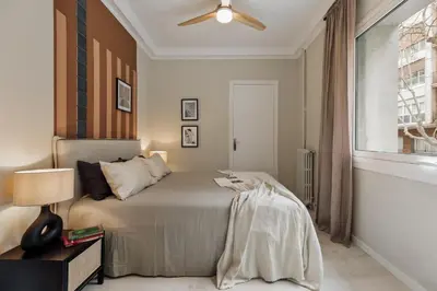 a living room with a bench and a kitchen at Cember - 3 bedrooms and patio in Sant Gervasi in Barcelona