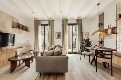 a kitchen with black cabinets and a dining room table at Orosi - 2 bedrooms and balcony in Poble Sec in Barcelona
