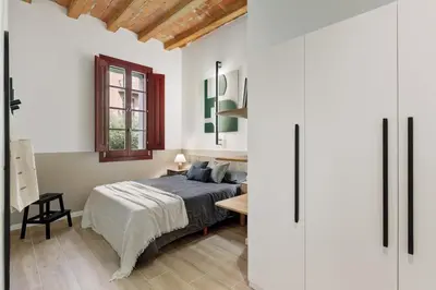 a bedroom with a bed and a table with a lamp at Estiu - 2 bedrooms and balcony in Sant Antoni in Barcelona